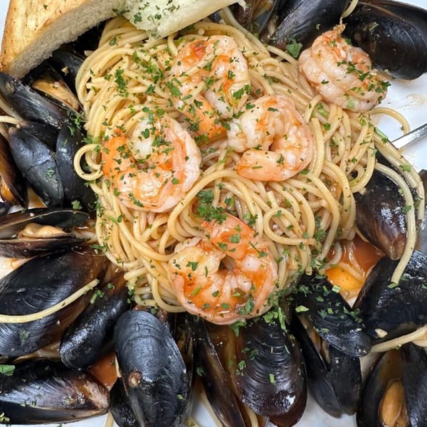 Vino Cappuccino's spaghetti with shrimp, mussels, and parsley, served with toasted bread.