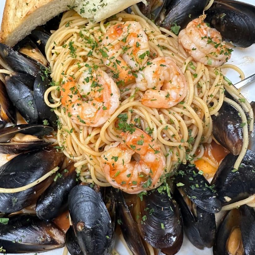 Vino Cappuccino's spaghetti with shrimp, mussels, and parsley, served with toasted bread.